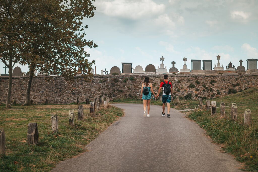 Couple walking by a path near a cemetery in Europe